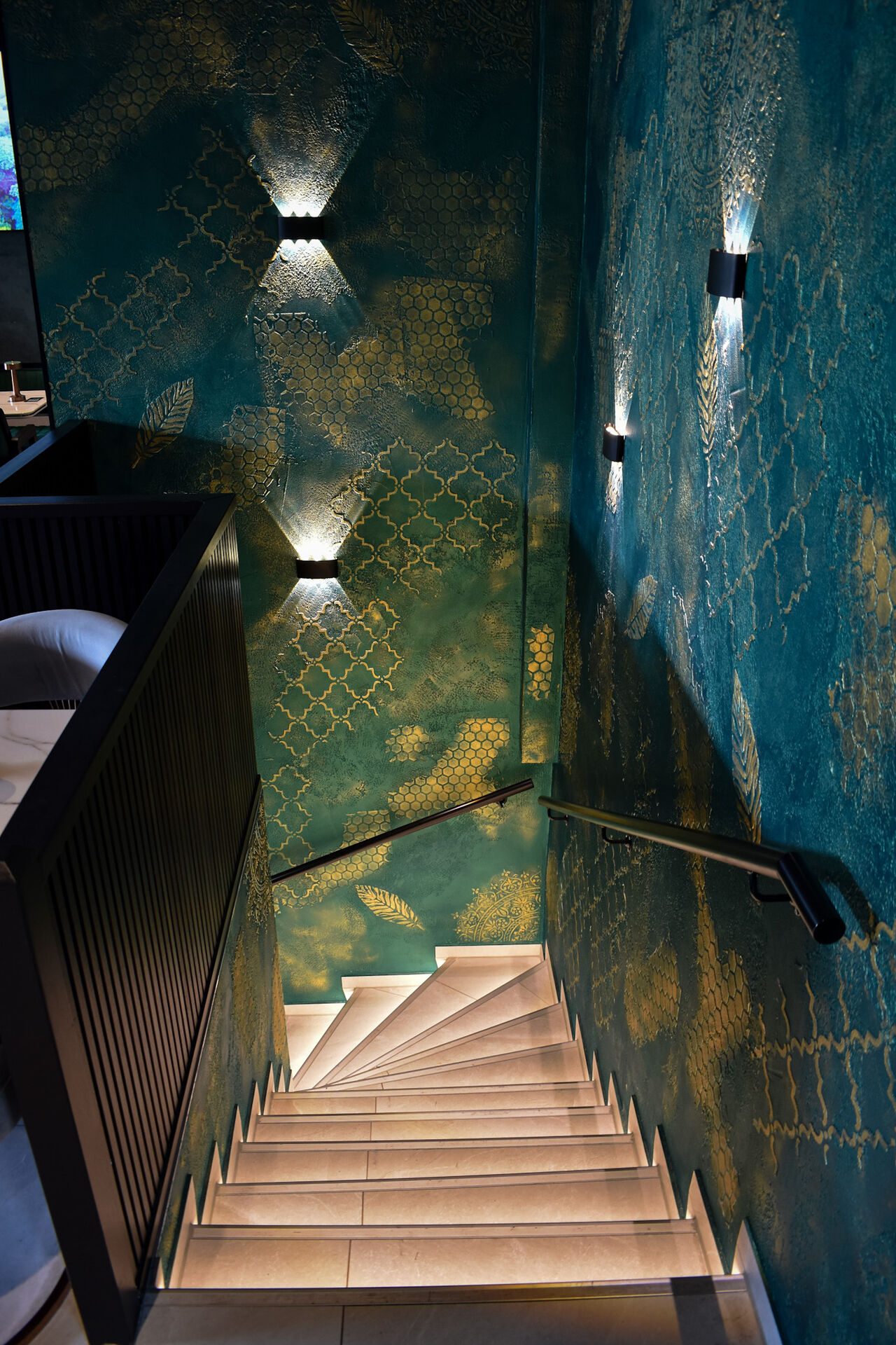 Treppe mit petrolfarbener Wand und Goldornament